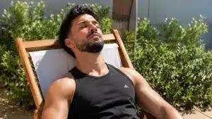 Homme musclé en débardeur qui bronze sur un transat pendant ses vacances d'été