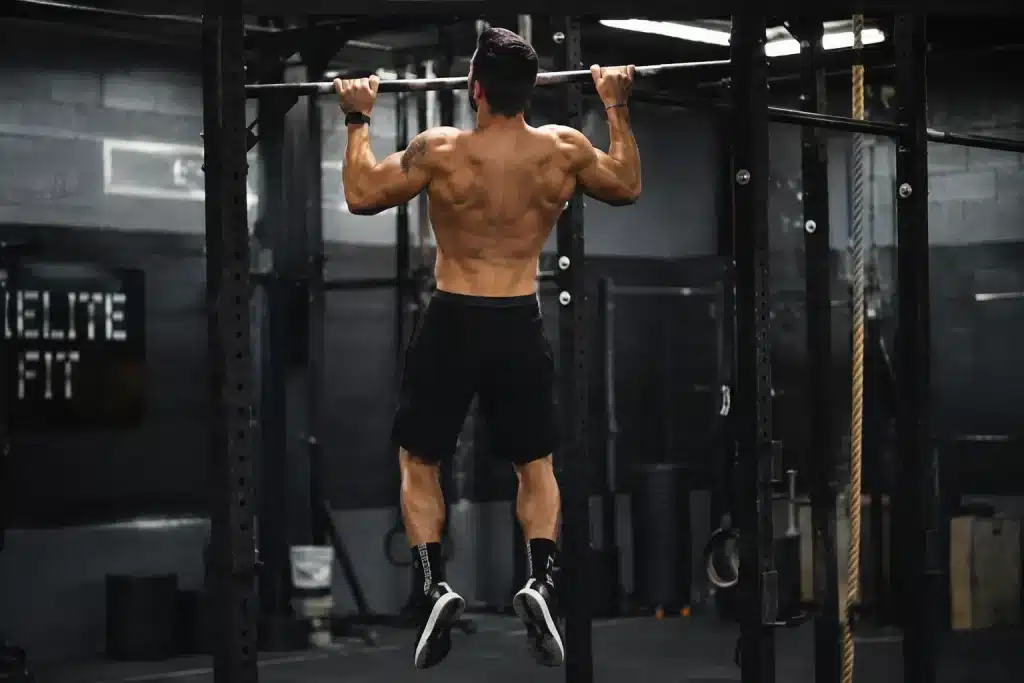 Homme réalisant des tractions sur une barre lors d'un entraînement de CrossFit Cindy